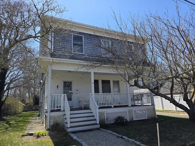 view of front of house with a porch, a front lawn, and fence