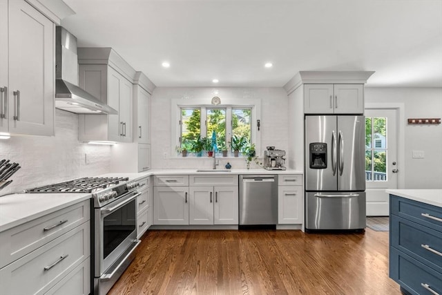 57 Glenham St, Boston, MA 02132 - kitchen with stainless steel appliances, wall chimney exhaust hood, tasteful backsplash, healthy amount of natural light, and recessed lighting
