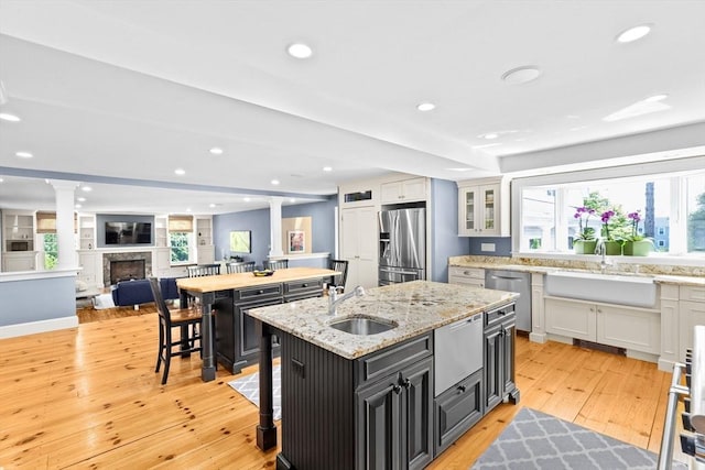 148 Pond St, Cohasset, MA 02025 - kitchen with a sink, appliances with stainless steel finishes, a center island with sink, decorative columns, and recessed lighting