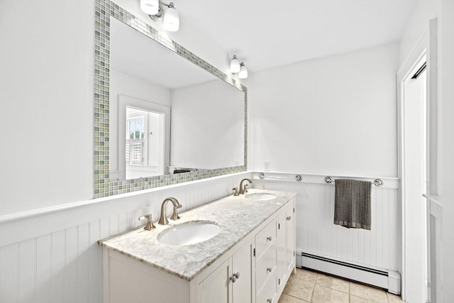 148 Pond St, Cohasset, MA 02025 - bathroom with a baseboard heating unit, a wainscoted wall, double vanity, and tile patterned flooring
