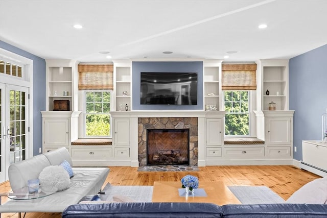 148 Pond St, Cohasset, MA 02025 - living room featuring healthy amount of natural light, a stone fireplace, light wood finished floors, recessed lighting, and baseboard heating