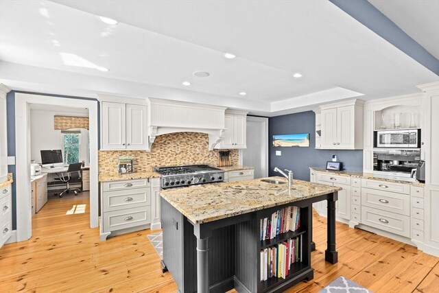 148 Pond St, Cohasset, MA 02025 - kitchen with stainless steel microwave, open shelves, tasteful backsplash, range, and light wood-style floors