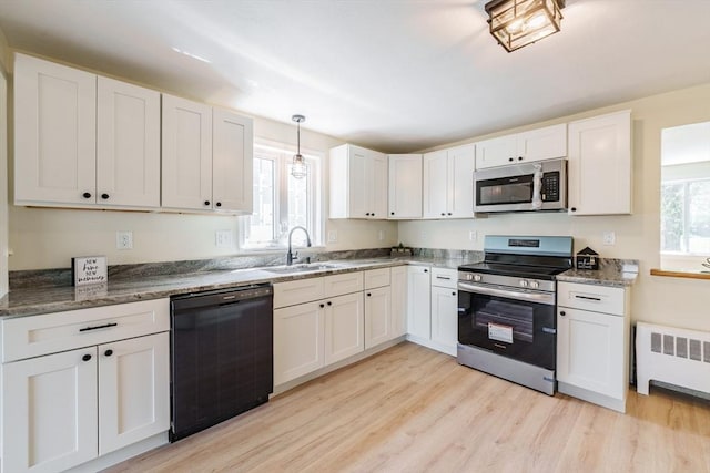 76 Wolcott Ave, West Springfield, MA 01089 - kitchen with appliances with stainless steel finishes, radiator, a sink, light wood-type flooring, and white cabinets