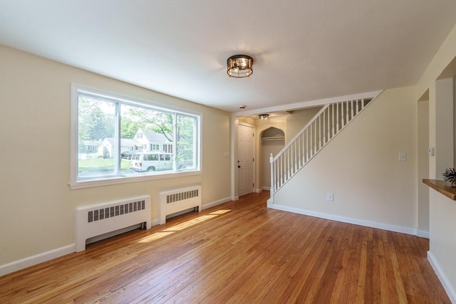 76 Wolcott Ave, West Springfield, MA 01089 - entrance foyer with radiator, arched walkways, stairway, and wood finished floors