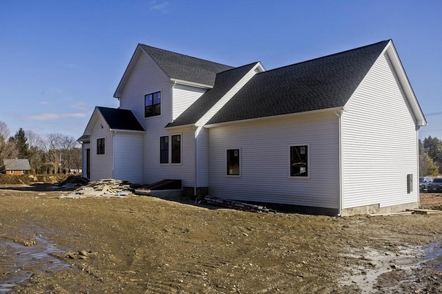 rear view of property with a shingled roof