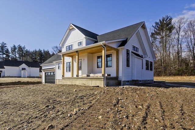 modern farmhouse style home featuring covered porch, an attached garage, and board and batten siding