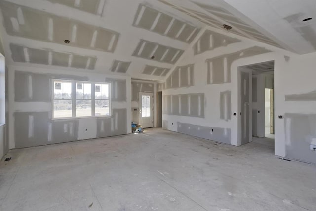 unfurnished living room with vaulted ceiling and a wealth of natural light