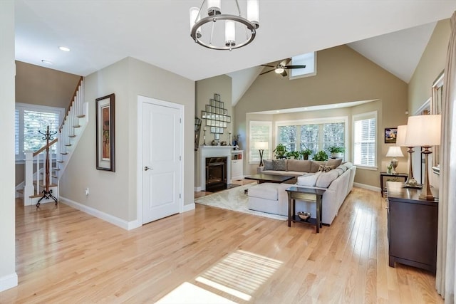 living room with stairway, light wood-style flooring, baseboards, and a wealth of natural light