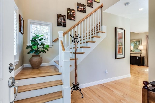 stairway with baseboards and wood finished floors