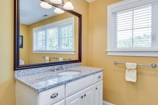 bathroom with a wealth of natural light, visible vents, and vanity