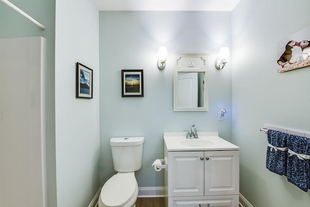 bathroom with vanity, toilet, and baseboards