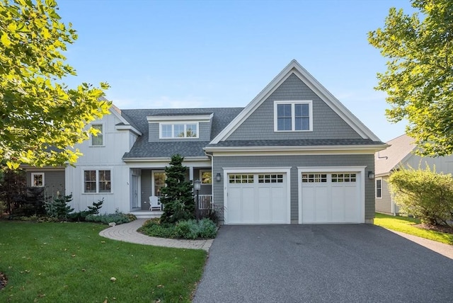 view of front of house with aphalt driveway, an attached garage, a front lawn, and a shingled roof