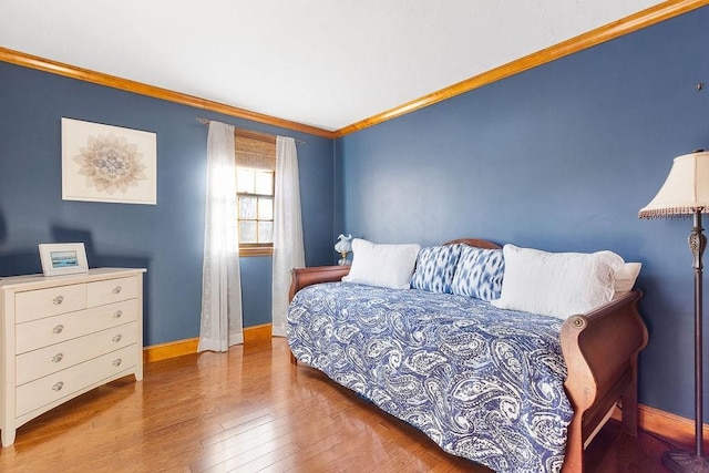 bedroom featuring wood-type flooring, baseboards, and crown molding