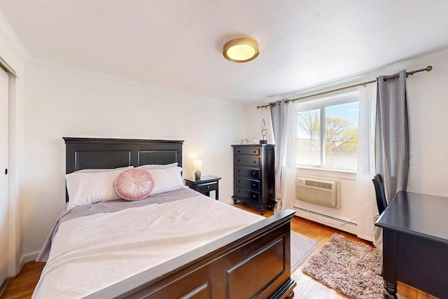95 Maple St Unit 21, Malden, MA 02148 - bedroom with light wood finished floors, ornamental molding, a wall unit AC, and a baseboard heating unit