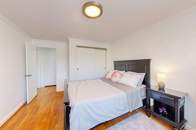95 Maple St Unit 21, Malden, MA 02148 - bedroom featuring crown molding, light wood-style flooring, baseboards, and a closet