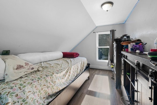 bedroom with dark wood-type flooring and lofted ceiling