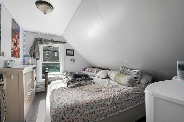 bedroom with lofted ceiling and dark hardwood / wood-style floors