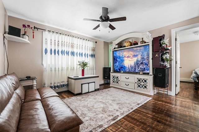 living room with dark wood-type flooring and ceiling fan