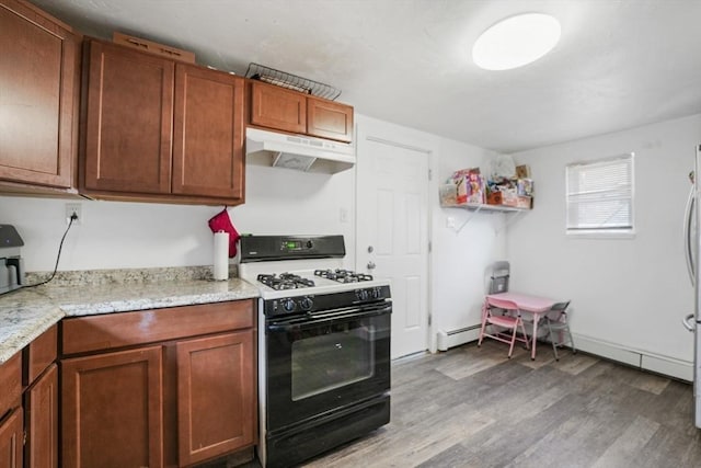 kitchen featuring light stone counters, range with gas stovetop, and hardwood / wood-style floors