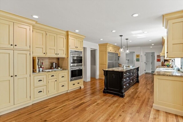 11 Ashford Ln, Andover, MA 01810 - kitchen featuring appliances with stainless steel finishes, cream cabinetry, recessed lighting, light wood-type flooring, and tasteful backsplash
