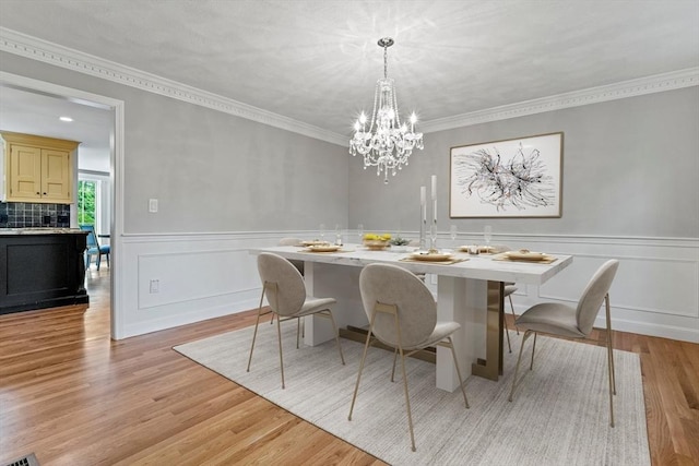 11 Ashford Ln, Andover, MA 01810 - dining room featuring light wood-type flooring, a chandelier, wainscoting, and crown molding