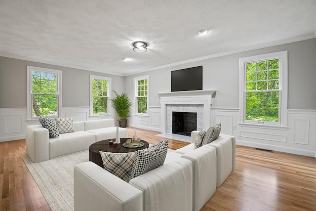 11 Ashford Ln, Andover, MA 01810 - living area featuring ornamental molding, wainscoting, a fireplace, light wood-style flooring, and a decorative wall
