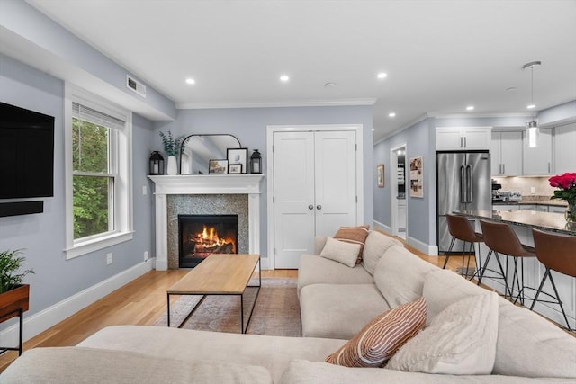 34 Colgate Rd Unit 3, Boston, MA 02131 - living room featuring a glass covered fireplace, light wood-style flooring, baseboards, ornamental molding, and recessed lighting