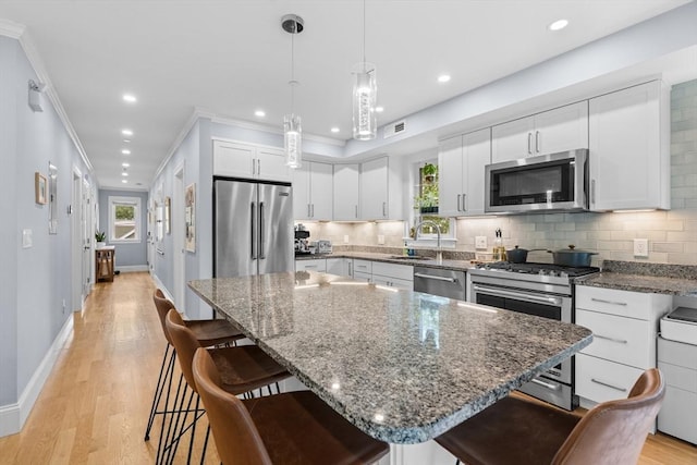 34 Colgate Rd Unit 3, Boston, MA 02131 - kitchen featuring stainless steel appliances, a sink, a kitchen bar, tasteful backsplash, and crown molding
