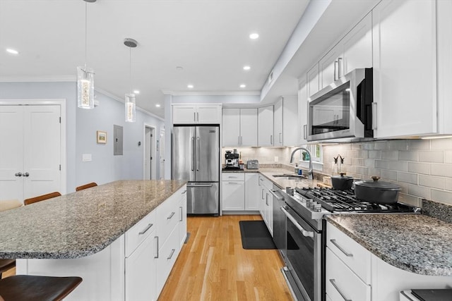 34 Colgate Rd Unit 3, Boston, MA 02131 - kitchen with appliances with stainless steel finishes, a sink, crown molding, light wood finished floors, and backsplash
