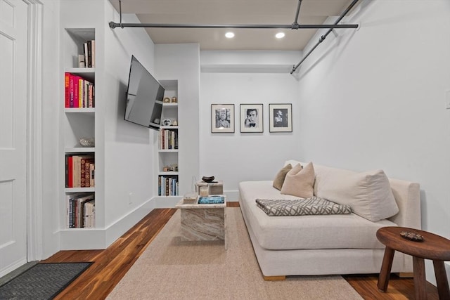 living area with built in shelves, dark wood finished floors, and recessed lighting