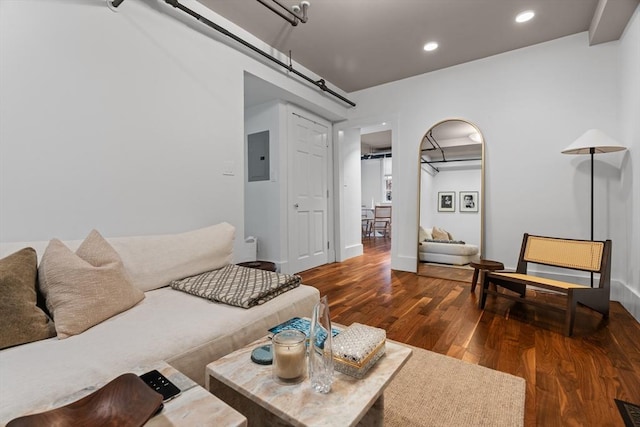 living area with wood finished floors, electric panel, recessed lighting, and baseboards