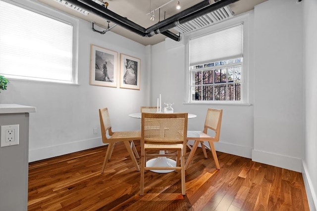dining area featuring wood finished floors, plenty of natural light, and baseboards