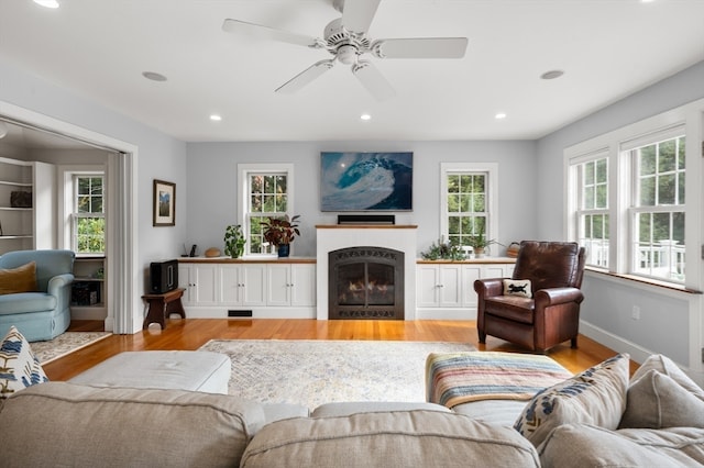 living room with light wood-type flooring and ceiling fan