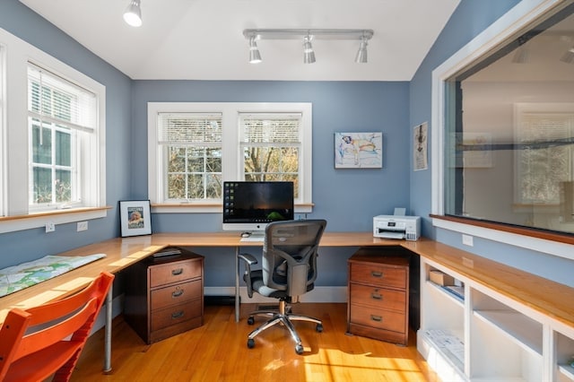 office area featuring a wealth of natural light, lofted ceiling, rail lighting, and light hardwood / wood-style floors