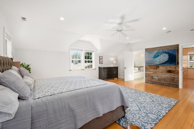 bedroom with light hardwood / wood-style flooring, connected bathroom, lofted ceiling, and ceiling fan