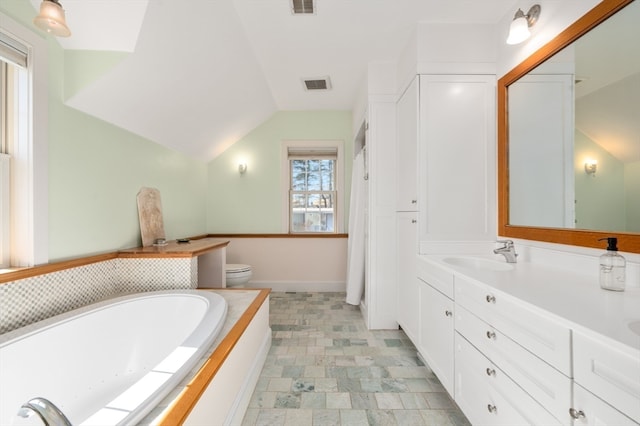 bathroom featuring a bath, toilet, lofted ceiling, and vanity