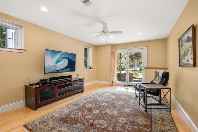 living area featuring light hardwood / wood-style flooring, a wealth of natural light, and ceiling fan