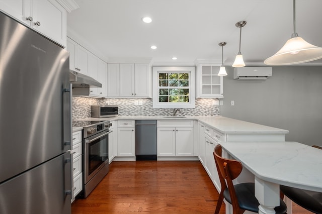 kitchen featuring pendant lighting, white cabinets, dark wood-type flooring, and stainless steel appliances