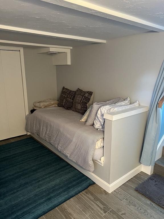 bedroom featuring beamed ceiling and dark hardwood / wood-style floors