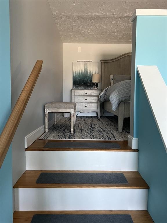 stairs with a textured ceiling