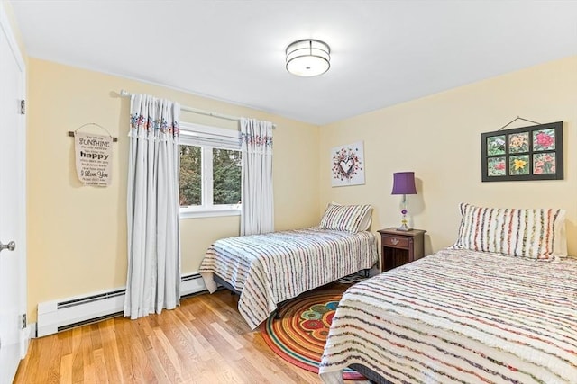 bedroom featuring baseboard heating and light hardwood / wood-style floors