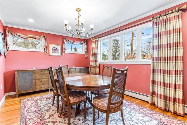 dining area with an inviting chandelier, a baseboard heating unit, wood-type flooring, and ornamental molding