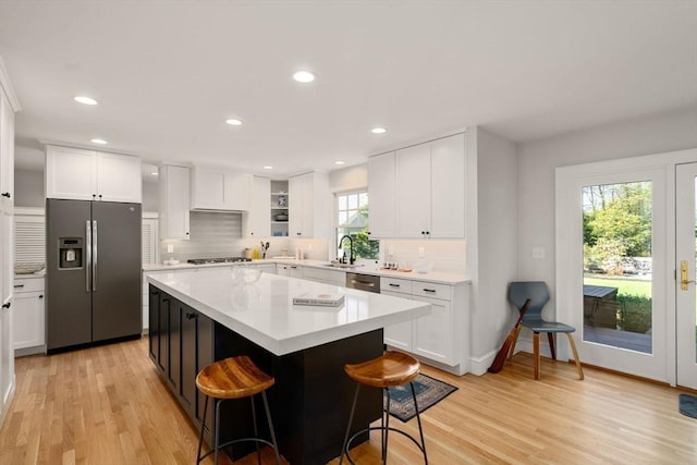 kitchen featuring a sink, appliances with stainless steel finishes, light wood-style floors, and light countertops