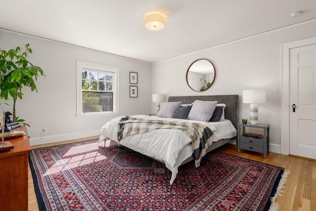 bedroom with baseboards and light wood-type flooring