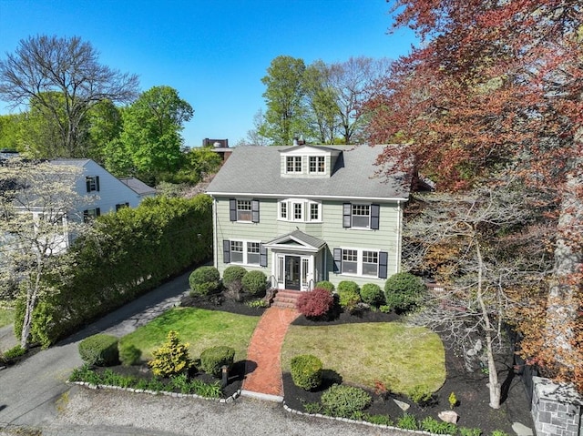 colonial house featuring a front lawn