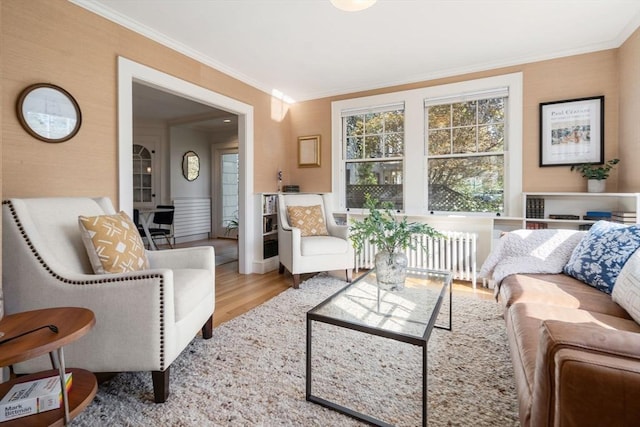 living room featuring radiator, ornamental molding, and wood finished floors