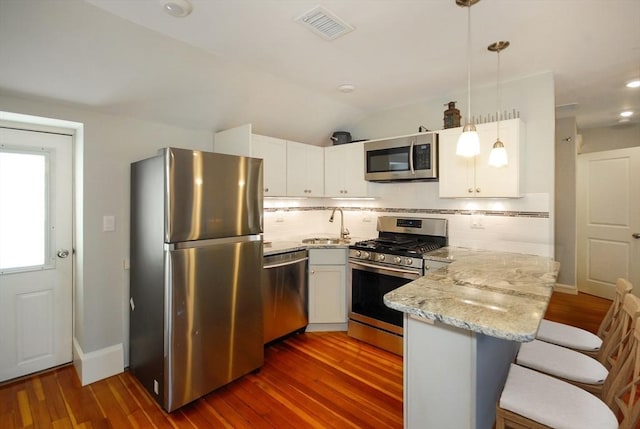 20 Beechwood Ave Unit B, Watertown, MA 02472 - kitchen with stainless steel appliances, a peninsula, dark wood-style floors, white cabinets, and vaulted ceiling