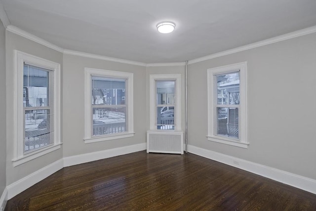 spare room featuring radiator heating unit, crown molding, and dark wood-type flooring