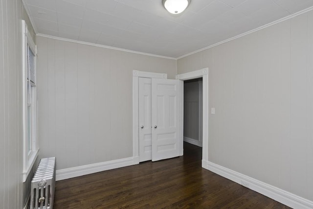 unfurnished bedroom with radiator, ornamental molding, dark hardwood / wood-style floors, and a closet