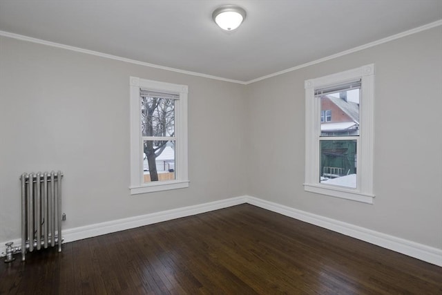 spare room featuring ornamental molding, radiator, and dark wood-type flooring